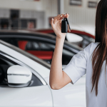 Mujer mostrando las llaves de su auto- conducción