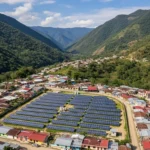 Fotografía aérea de paneles solares en una comunidad rural de Guatemala, rodeados de casas y montañas verdes.
