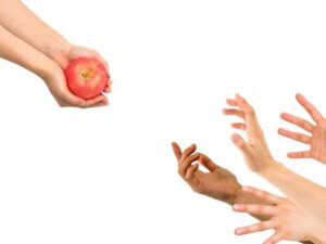 una mano ofreciendo una manzana a otras 4 manos, representando la oferta y la demanda