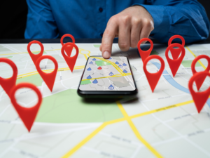 Una persona analizando un mapa digital en una tablet con marcadores de ubicaciones estratégicas para la apertura de nuevos restaurantes.