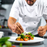 Personal de cocina siguiendo un manual de procedimientos estandarizados, simbolizando la calidad consistente en una cadena de restaurantes en expansión.