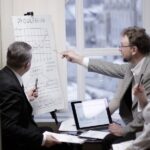 Equipo de empresarios en reunión con gráficas preparando estrategia comercial