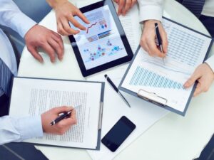 reportes financieros en un ipad y en papel, contrato para preparar una oferta